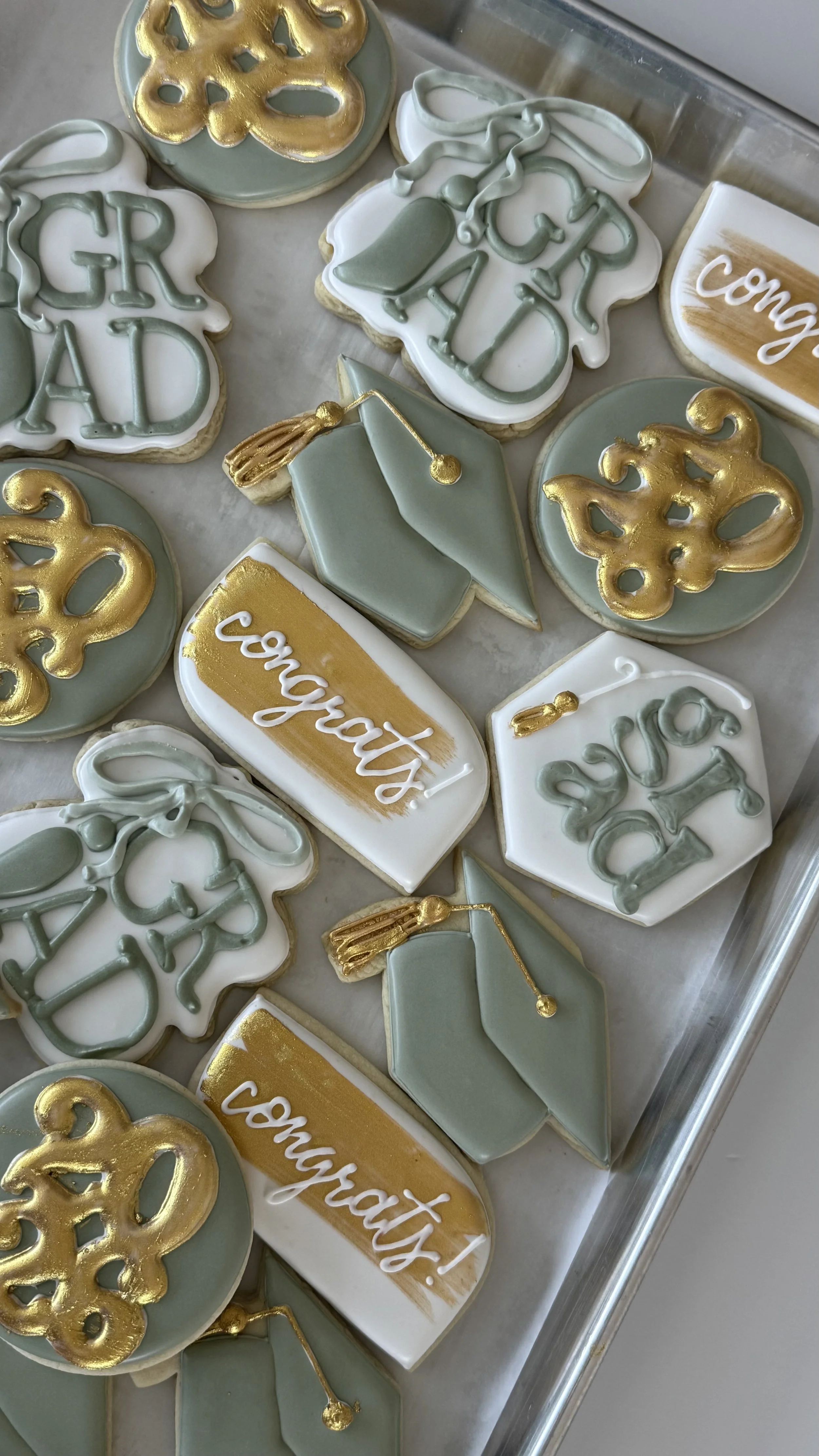 Decorative cookies with graduation theme, including diplomas, caps, messages like "congrats!" and 