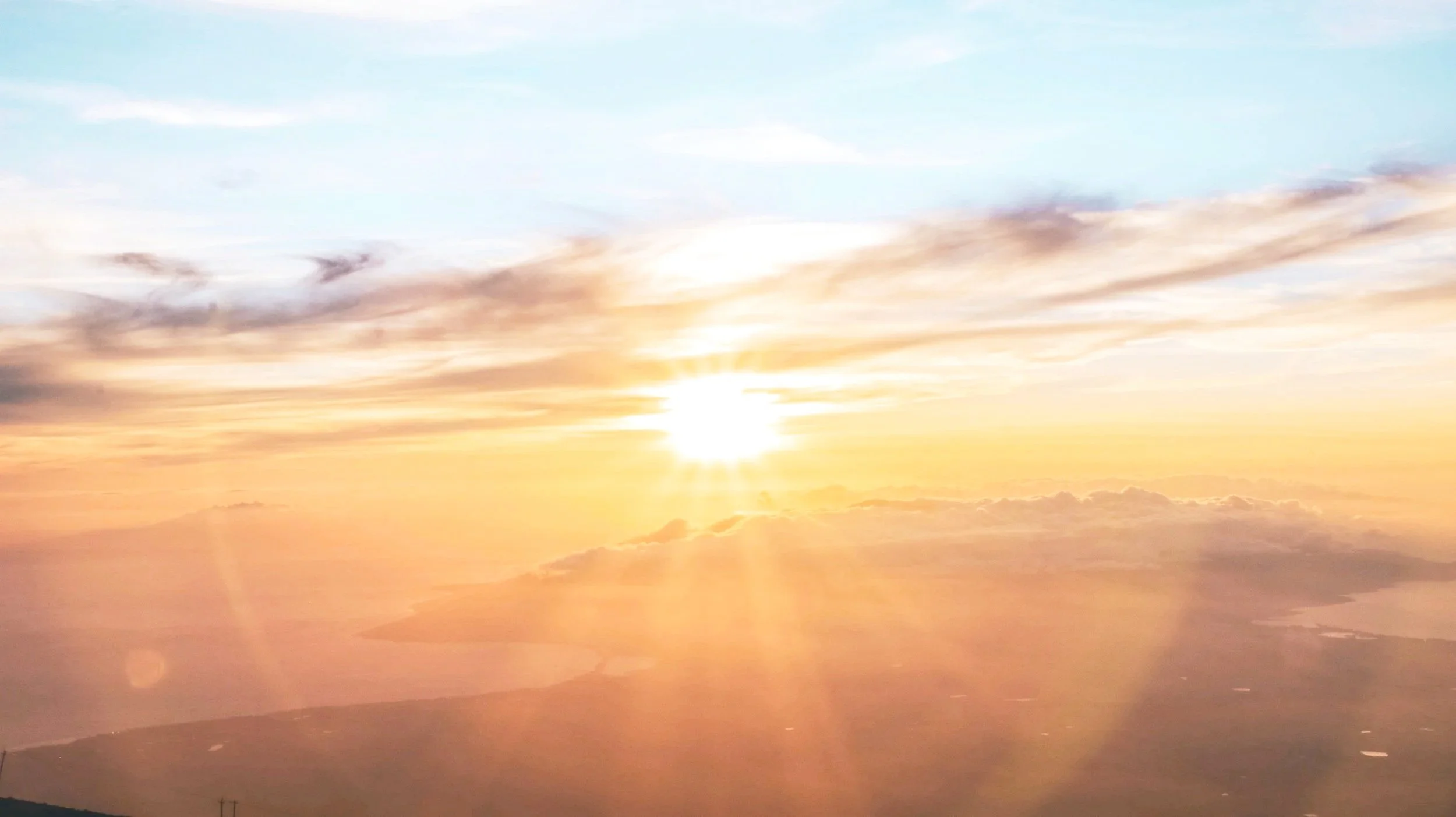 Sunset or sunrise over mountains with colorful clouds in the sky.