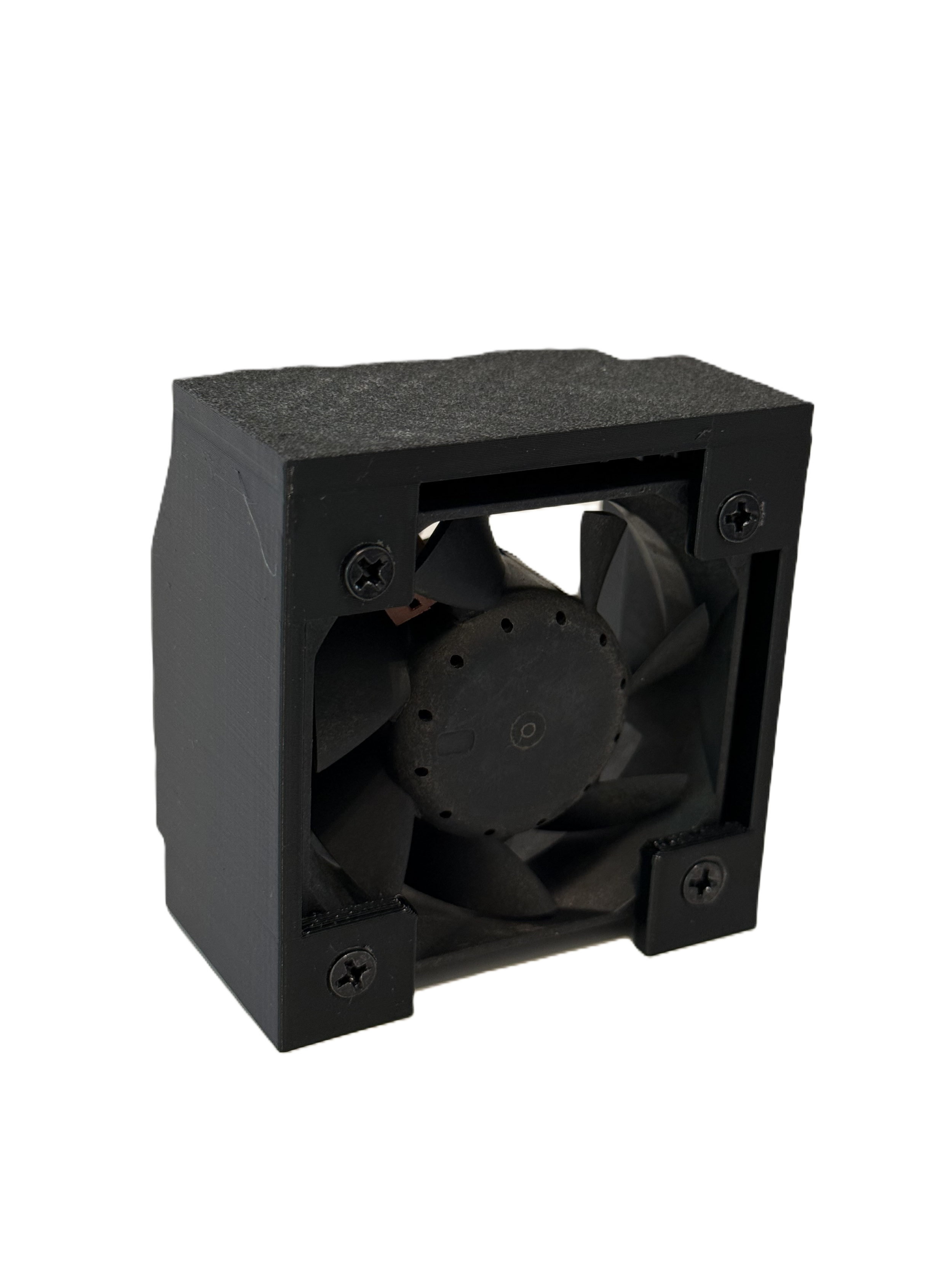 Close-up of a black computer cooling fan inside a rectangular black case, with visible screws on the case edges.
