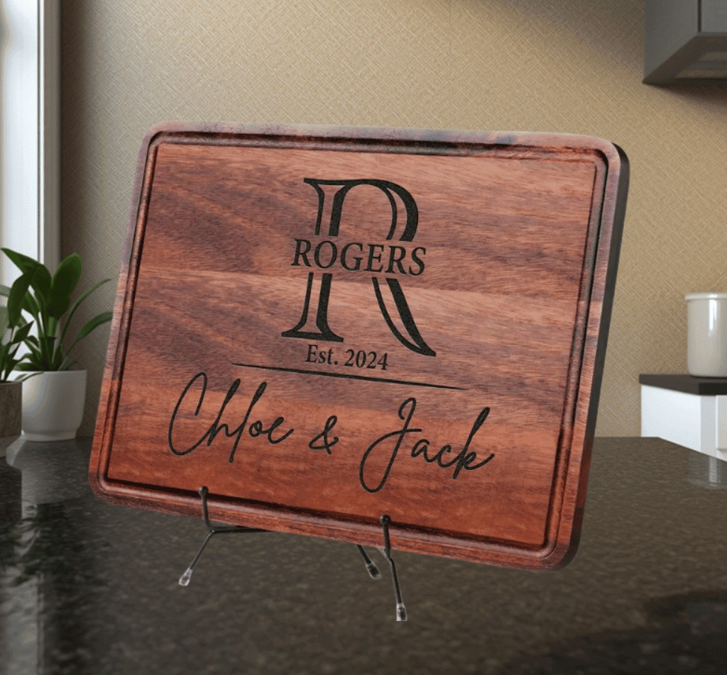 Wooden wedding sign with decorative design, placed on a countertop with a plant and kitchen elements in the background.