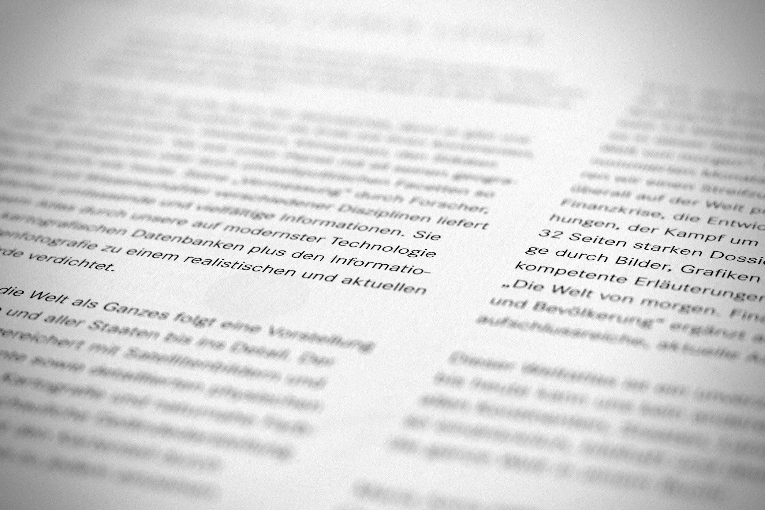 A close-up of a printed page with text, slightly blurred, showing paragraphs in German.