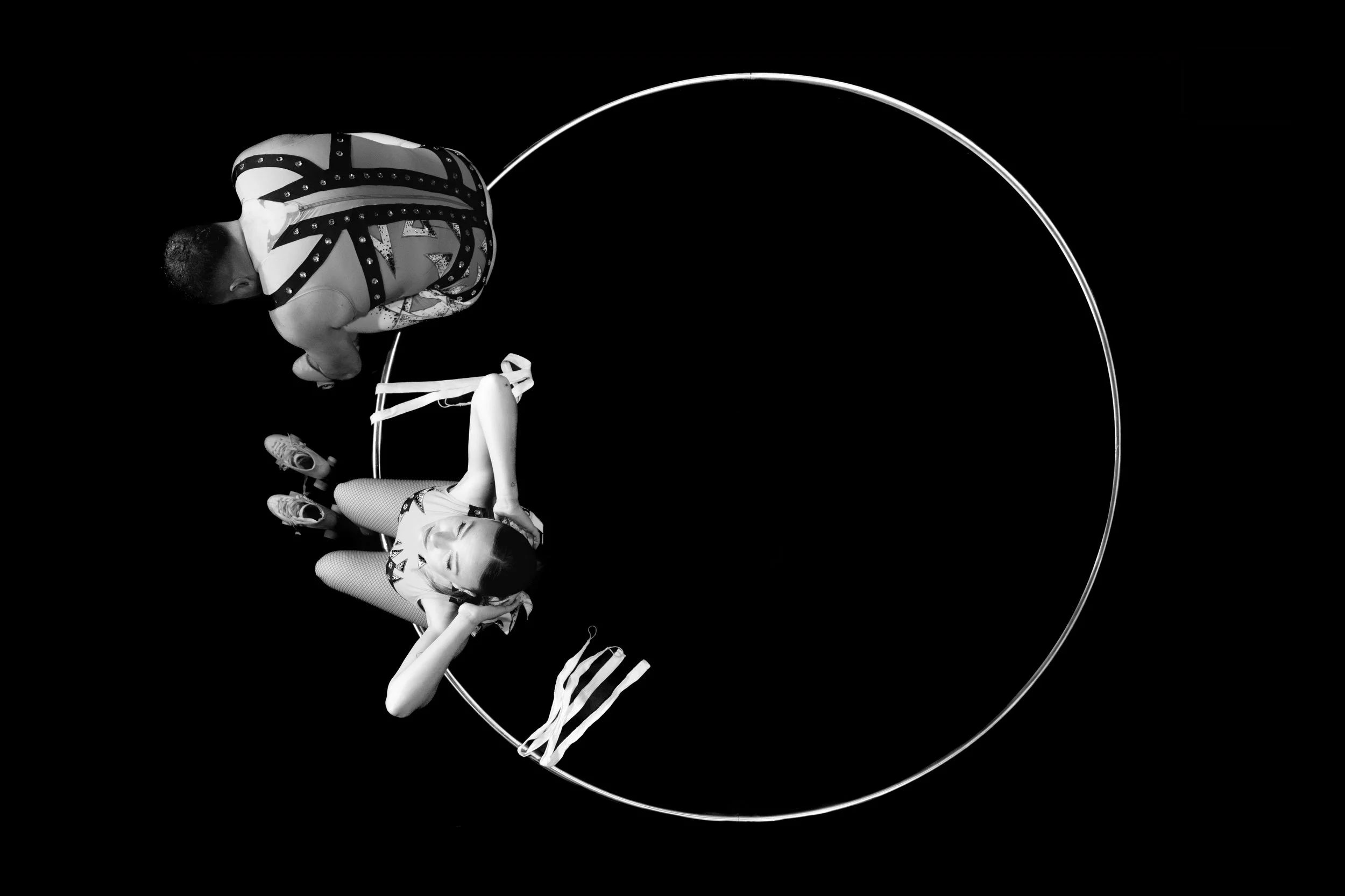Une femme et un homme, allongés dans une forme de cœur, en noir et blanc, avec un décor minimaliste.
