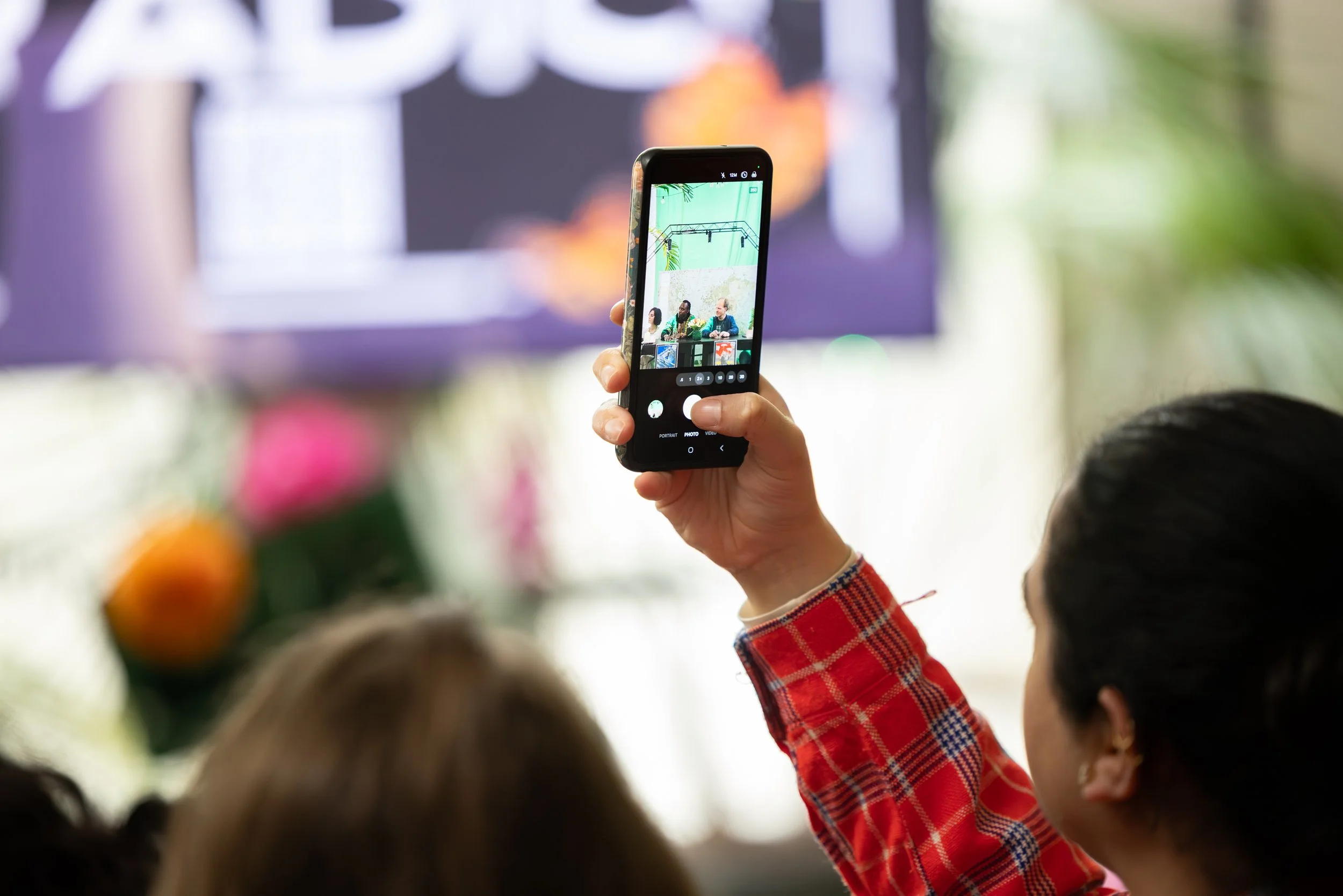 Person takes a photo through their smart phone during Resistance Radio