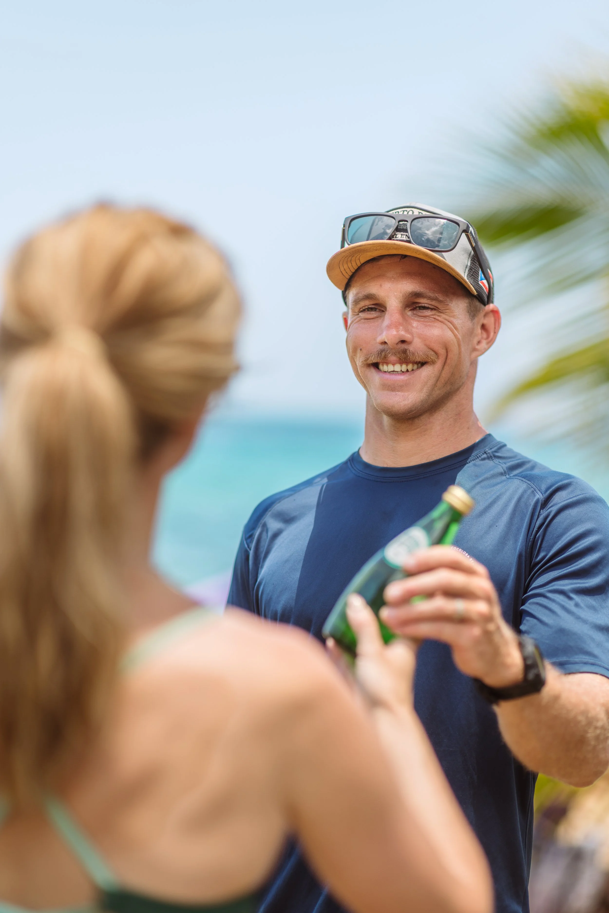 A Vantage Dive Club guest enjoying post-dive refreshments on the beach after a luxury scuba experience in Rincón, Puerto Rico.