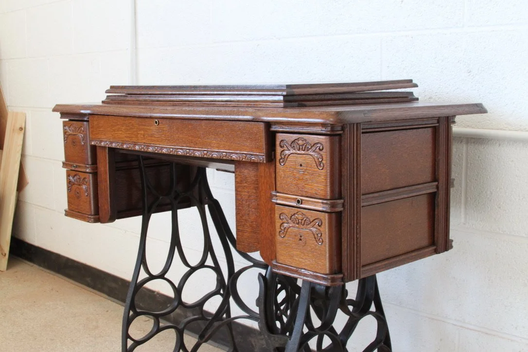 Vintage sewing machine with wooden cabinet and cast iron base
