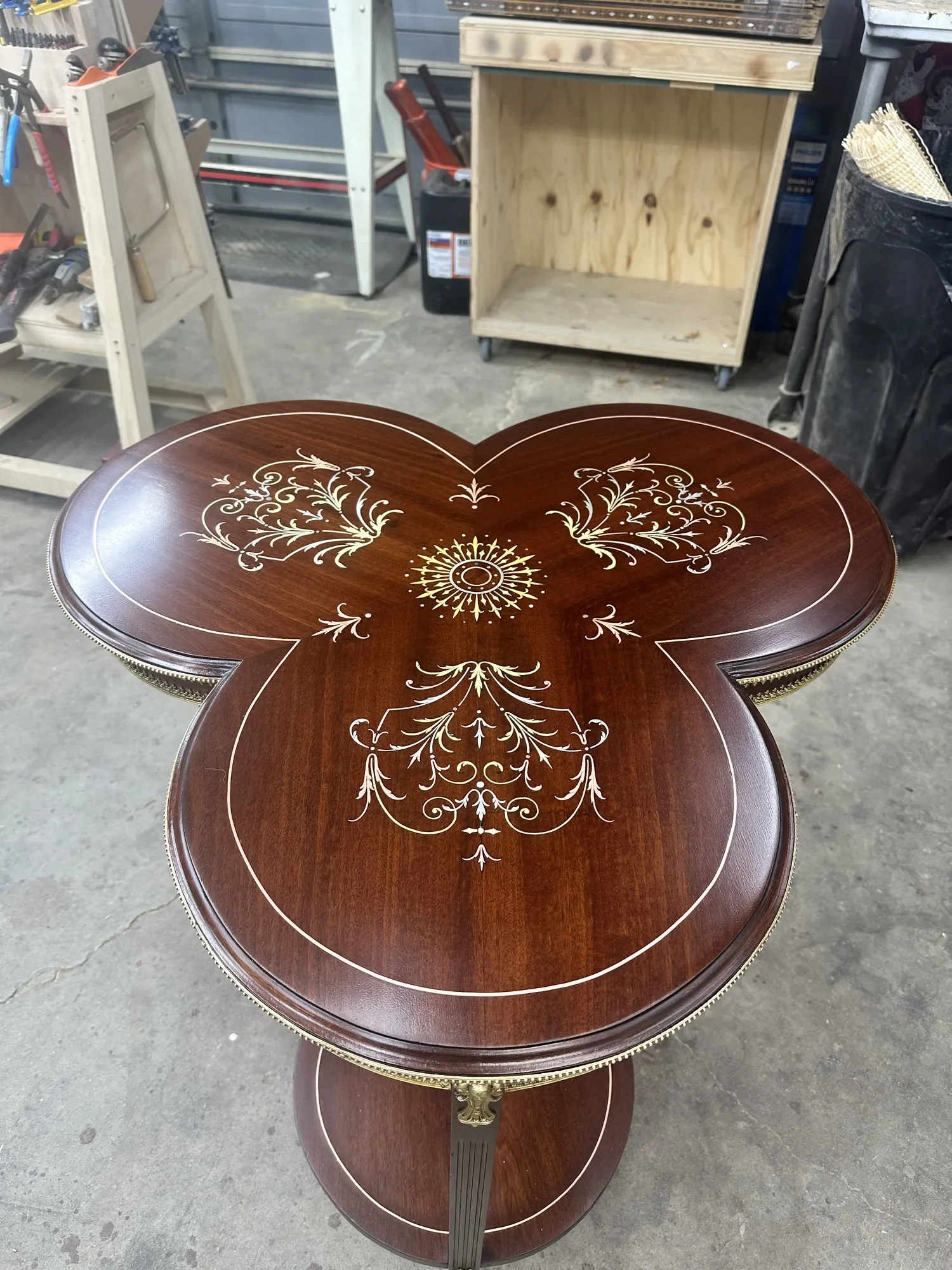 Restored trefoil tabletop showing crisp sunburst and scrollwork inlay against deep mahogany