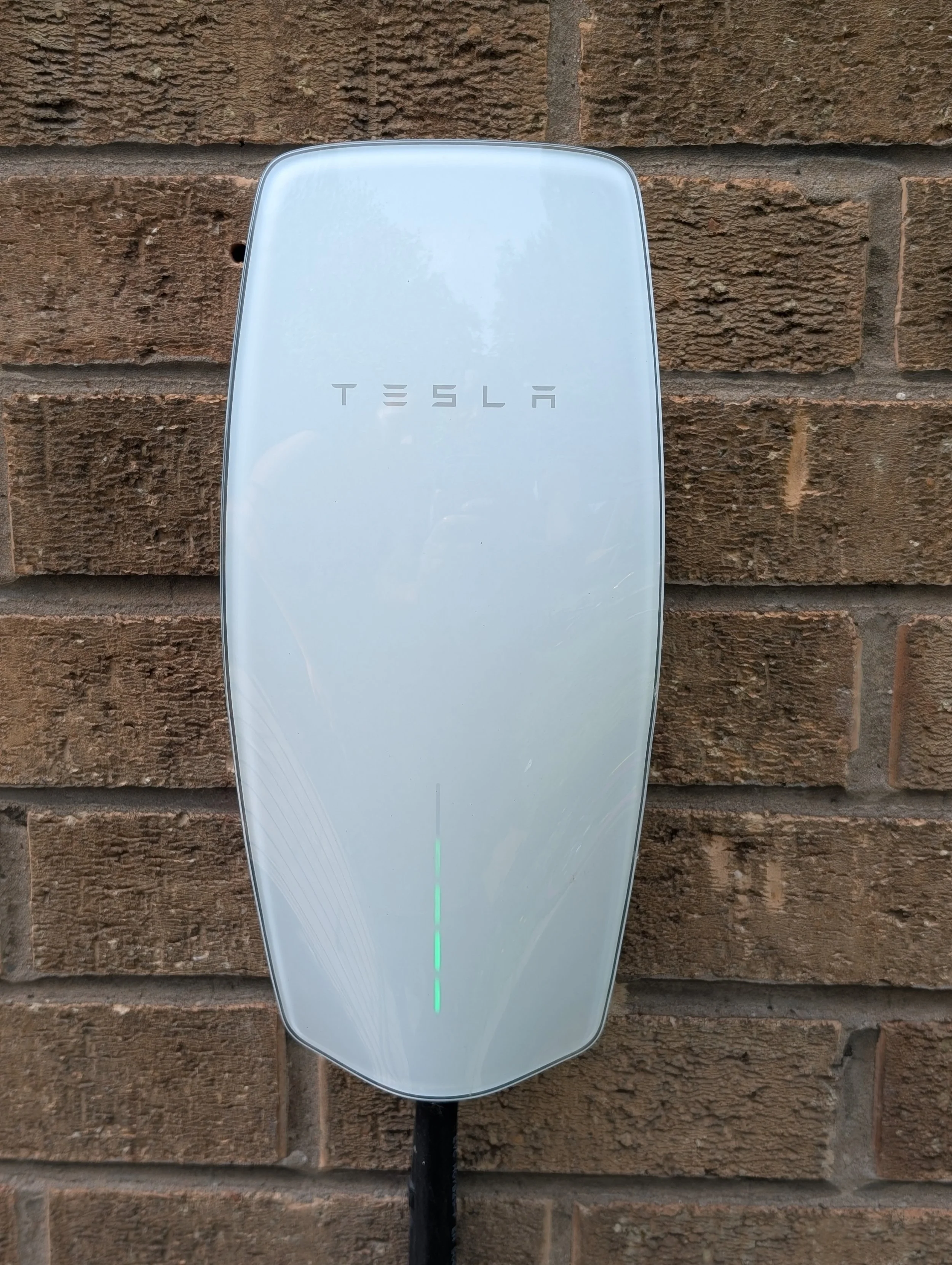 Tesla Ev Charger installed on brick wall in manchester