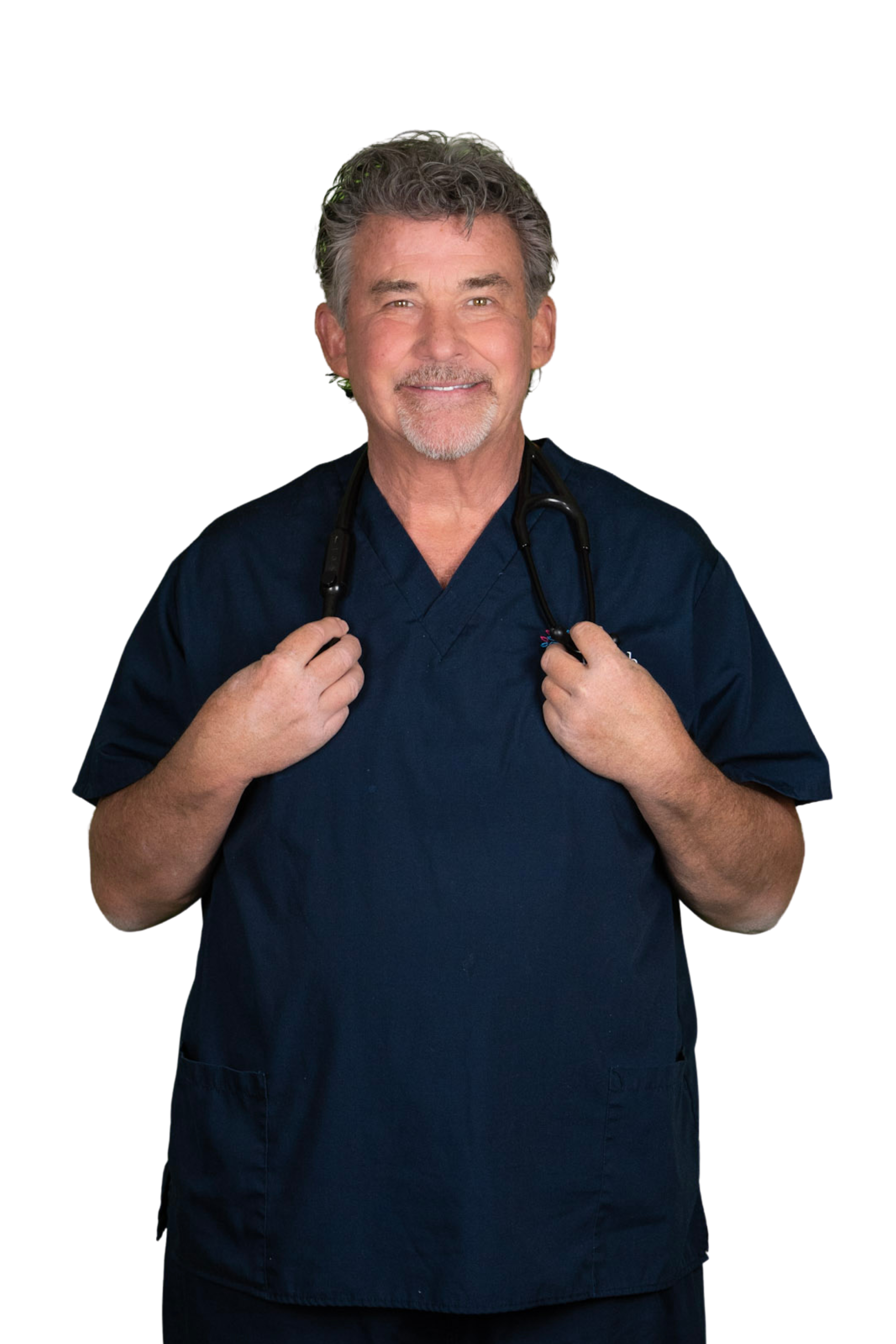 A smiling male healthcare professional wearing dark blue scrubs and a stethoscope around his neck, holding it with both hands, against a plain white background.