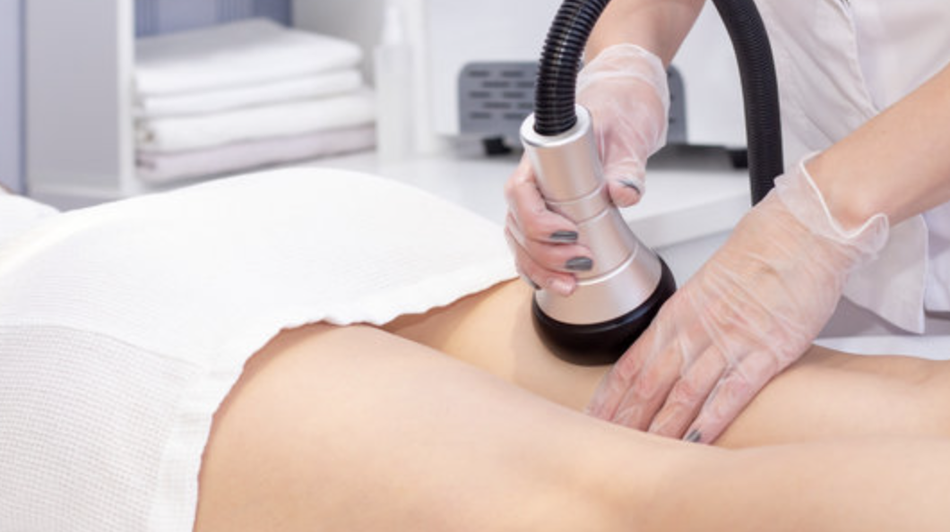 A Certified Body Contouring Specialist  using a Vacuum RF device on the patient's back of their thigh for a cellulite treatment.
