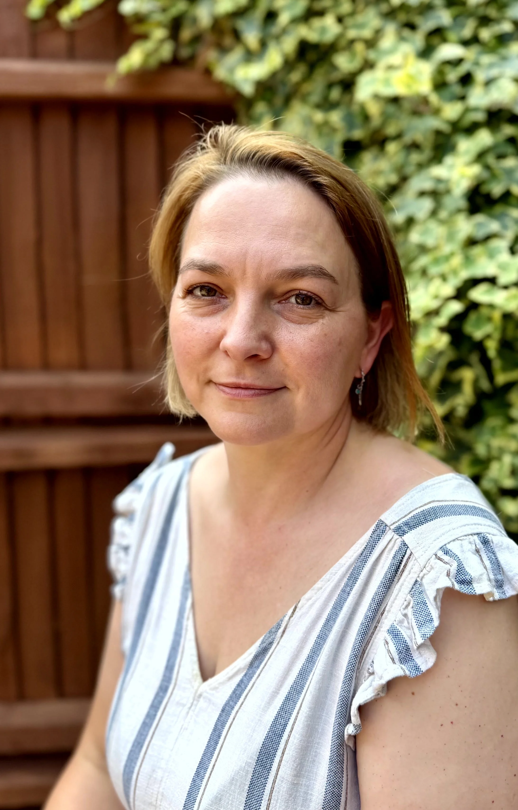 Portrait of artist Eugenia Tranca sitting outdoors in Dorset, UK, reflecting her fine art practice and studio environment