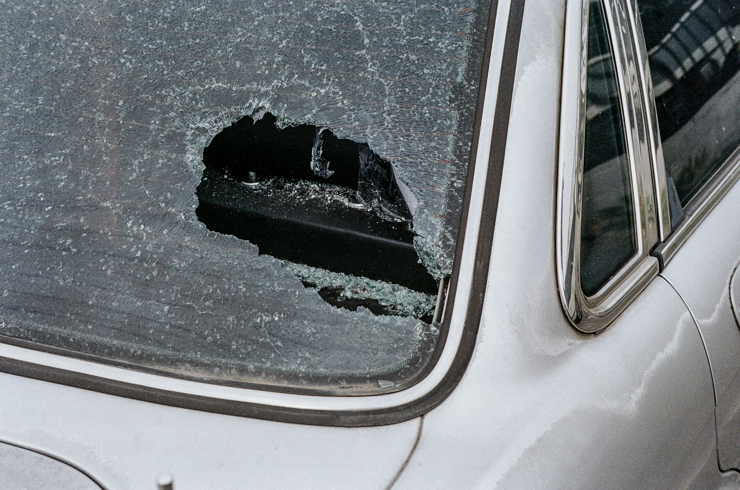 Car with a large hole and shattered glass on the window.