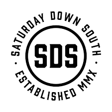 A circular logo with the text 'Saturday Down South' arcing around the top, 'Established MMX' arcing around the bottom, and a smaller circle in the center with the initials 'SDS' inside.