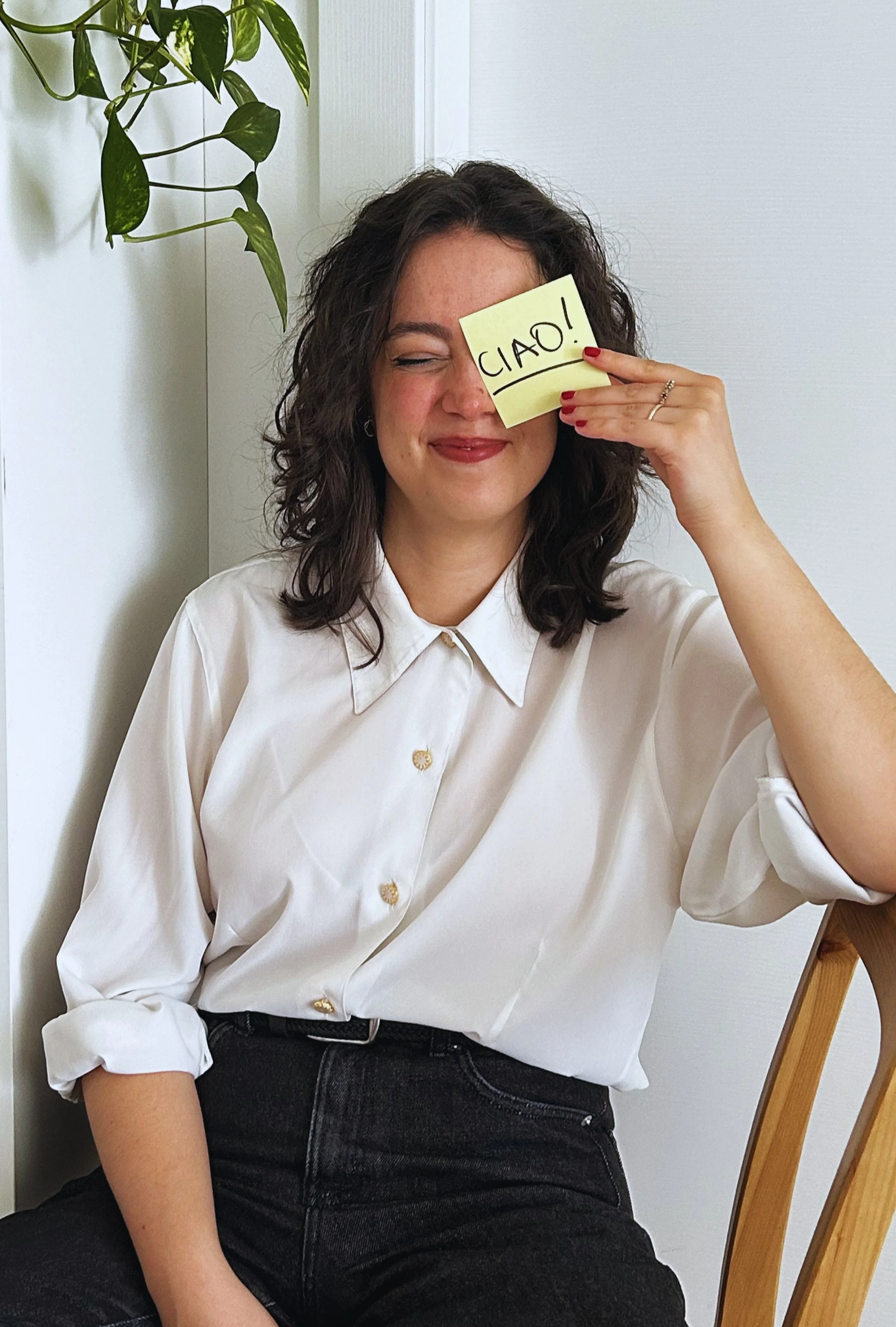 Beatrice Brentani sorride seduta mentre tiene in mano un biglietto con la scritta “Ciao”.