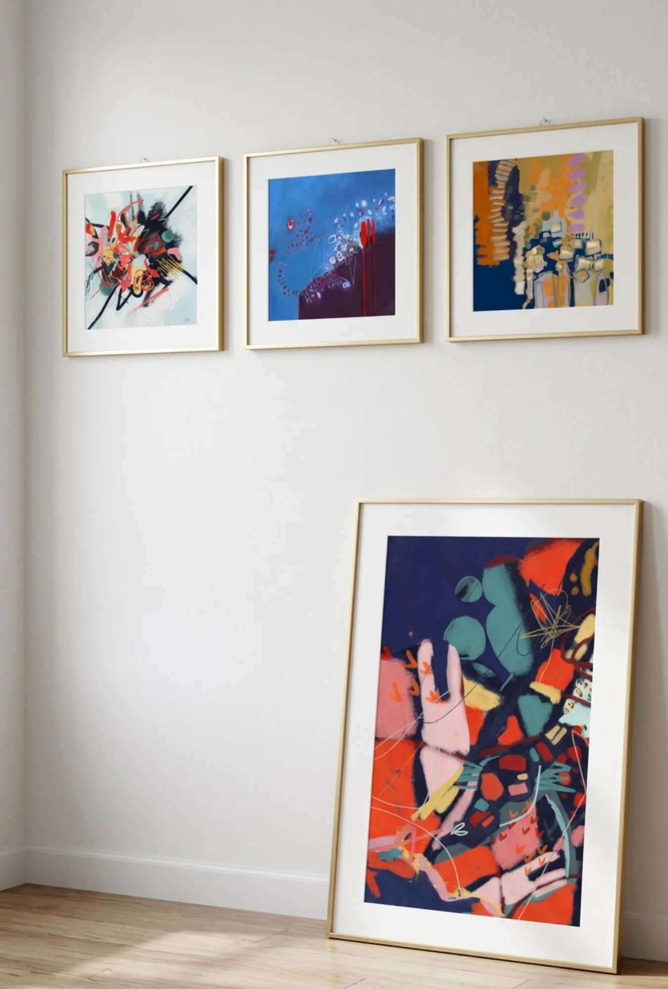 Image of an art gallery with three abstract paintings by Bainbridge Island artist Emily Whitish, on the wall and one leaning against the wall, featuring colorful, dynamic, and expressive patterns.