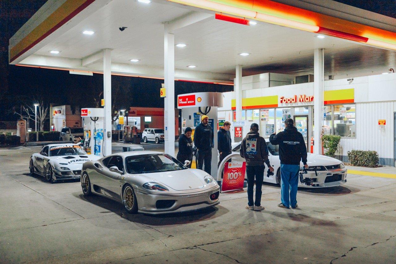 Exotic cars filling up gas in the early morning.