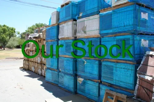 Stacked blue crates on a sidewalk with a sign overlay that reads "Our Stock".