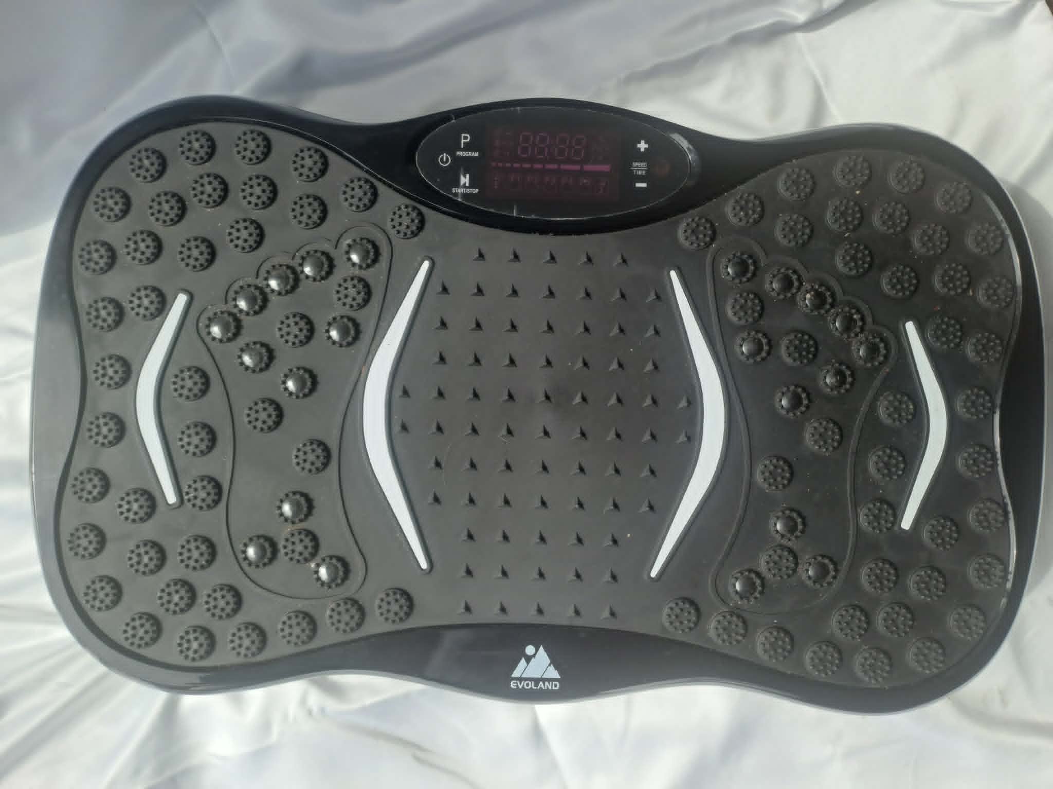 Top view of a black and gray inflatable balance board with textured surface, digital display, and control buttons in the center, branded with EVO LAND.