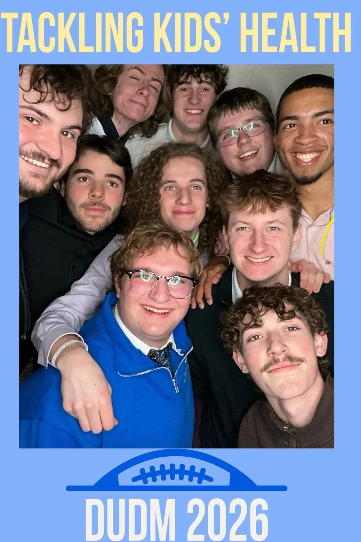 Group of young men taking a selfie at the DUDM 2026 event, standing close together and smiling.