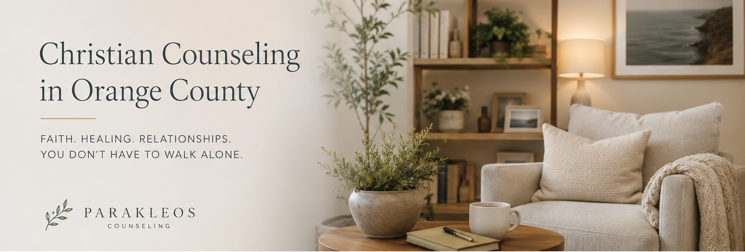 Living room with a beige sofa, pillows, a table with a plant, a notebook, and a mug, bookshelf, and framed ocean artwork, warm lighting