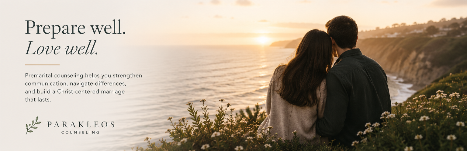 A couple sitting on the edge of a cliff watching the sunset over the ocean with hills and flowers in the foreground, promoting premarital counseling services.