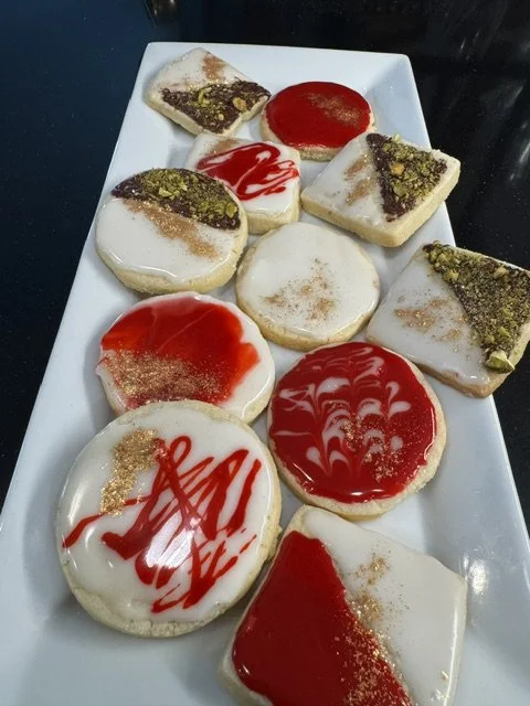 Assorted decorated cookies on a white rectangular plate.