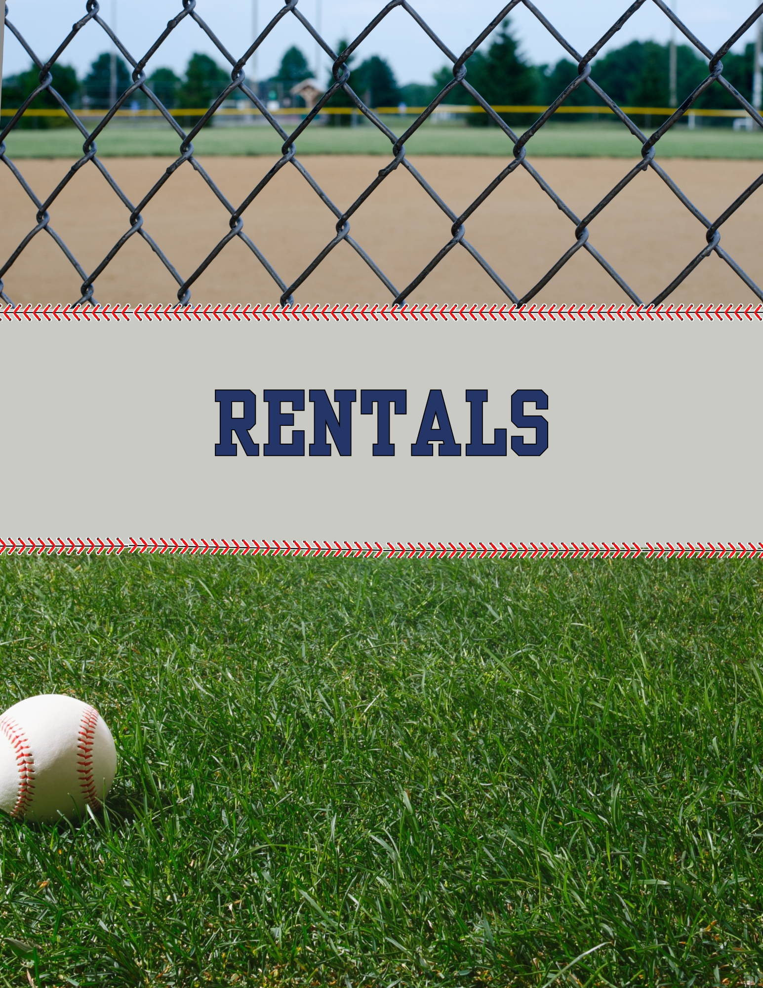 A baseball lying on green grass near a chain-link fence with a baseball field and trees in the background.