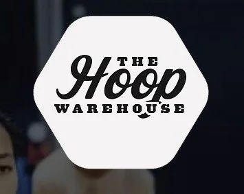 Logo for The Hoop Warehouse with black text on a white hexagon background.