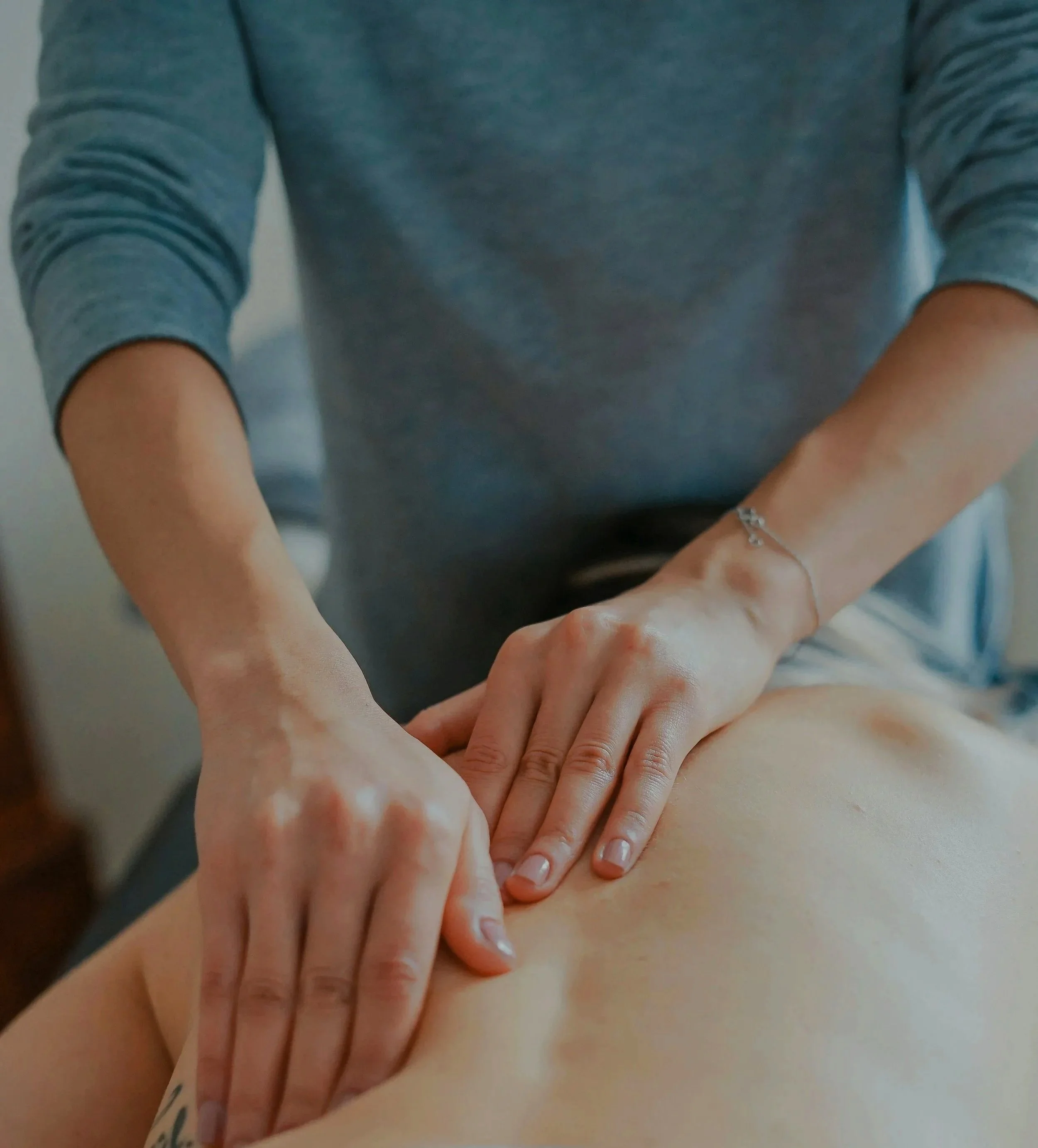 Multiple hands of different skin tones stacked on top of each other, symbolizing unity or teamwork.