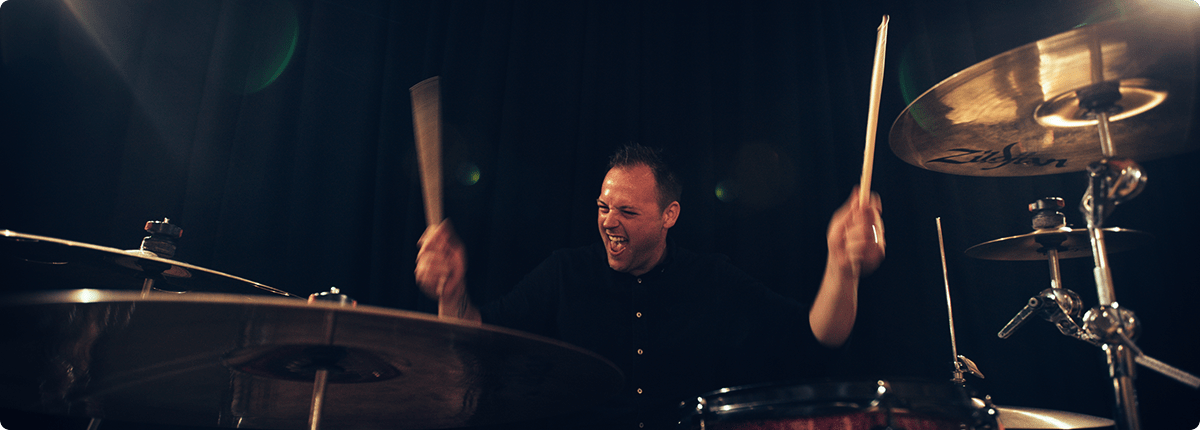 Revolve drummer performing live with drumsticks raised mid song