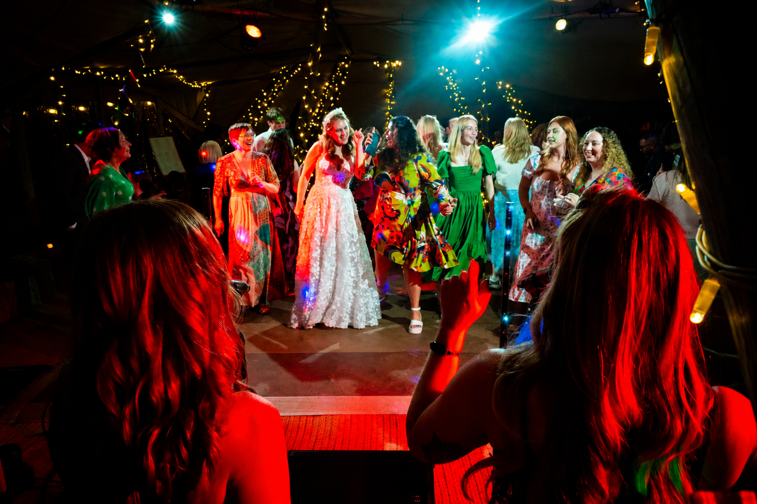Bride and wedding guests dancing together on a packed dance floor at a Revolve event