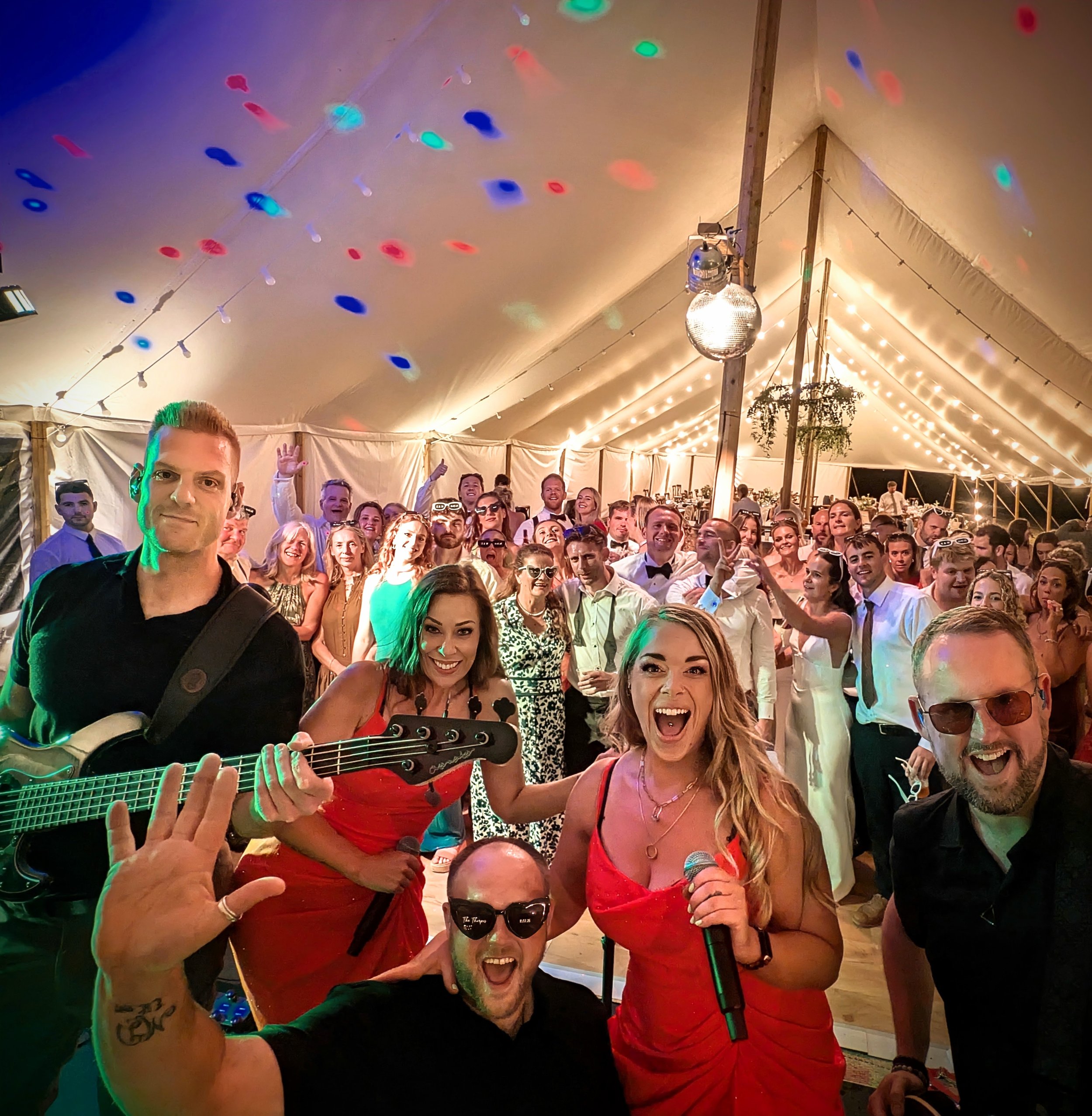 Guests celebrating with Revolve Party Band at a marquee wedding venue in Bedfordshire