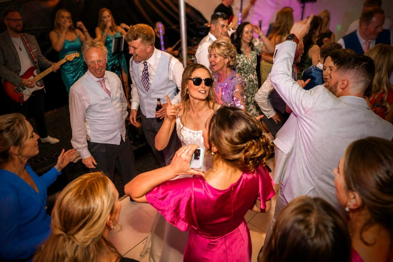Packed dance floor of wedding guests dancing and celebrating to Revolve Party Band