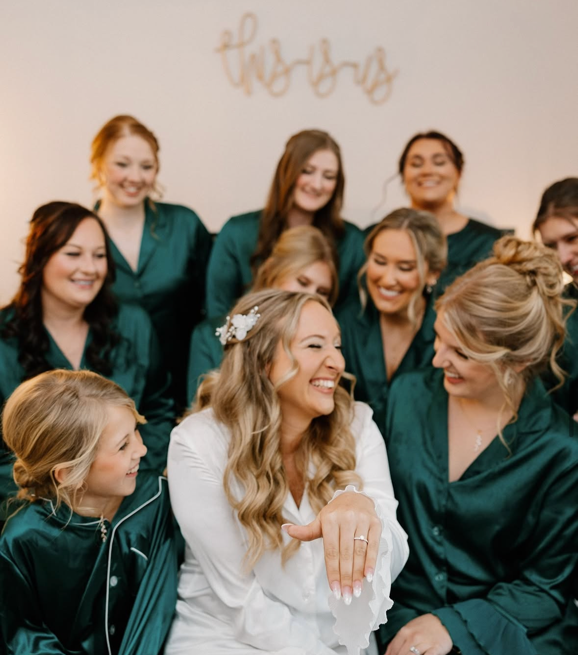 A bride in white robe with her wedding part promoting bridal makeup artist in Niles Ohio.