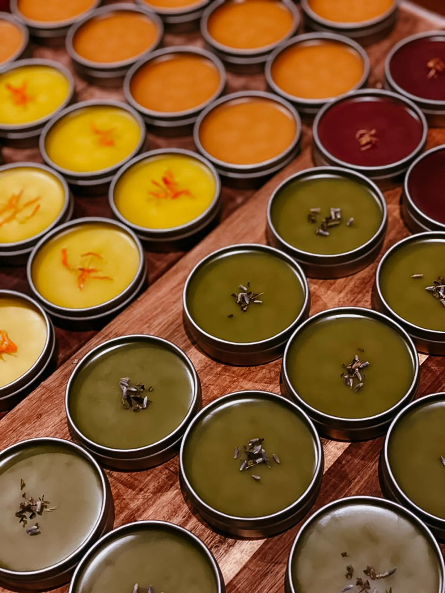 Various bowls of colorful Indian desserts arranged on a wooden surface.