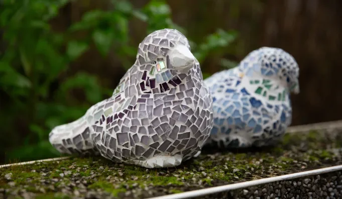 Two mosaic birds made from reclaimed ceramic fragments at Romã