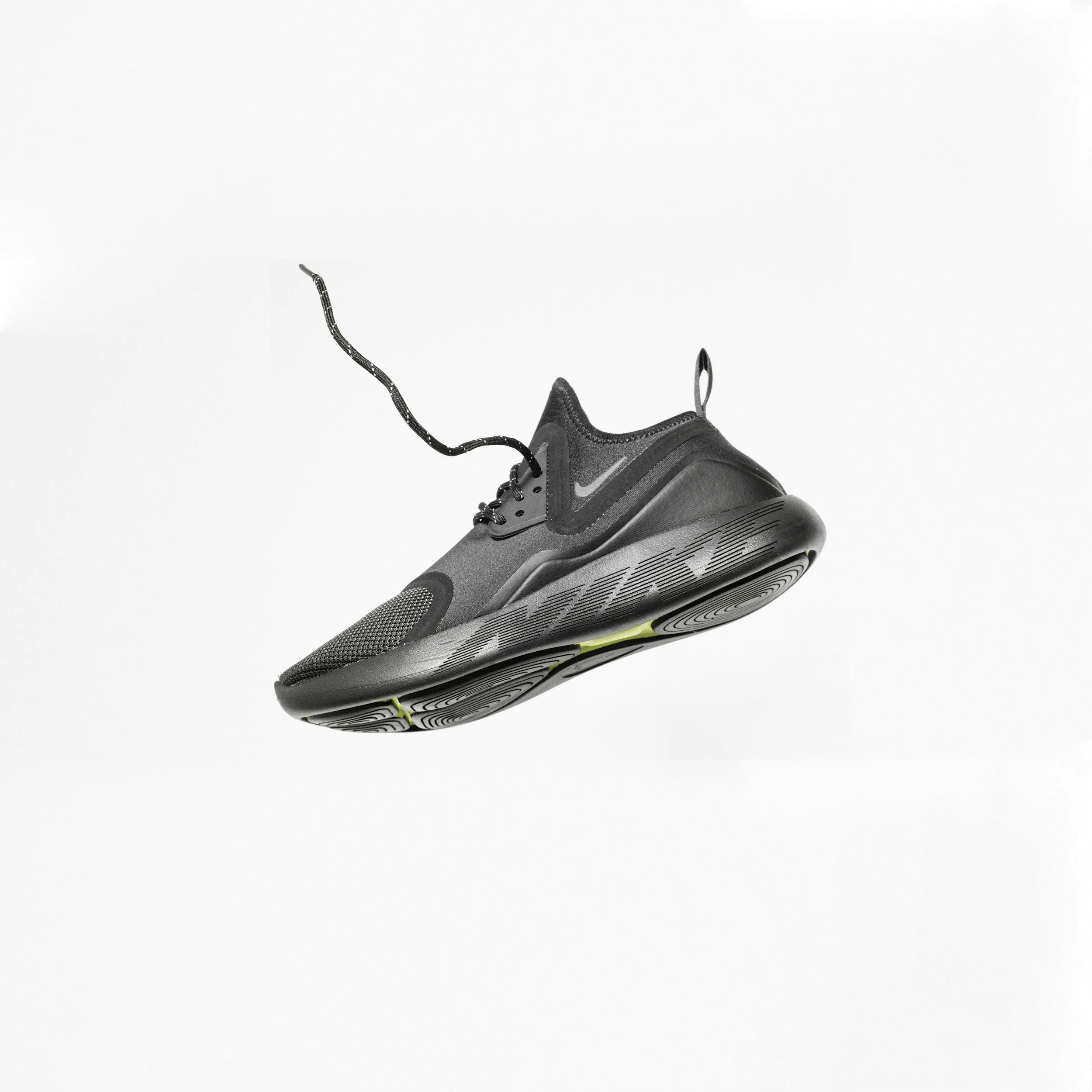 Close-up of a black and gray athletic shoe with a black laces and a geometric sole design.