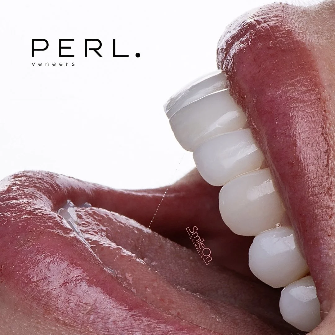 Close-up of a person with their mouth open, showing white teeth and tongue, with lip gloss on lips.