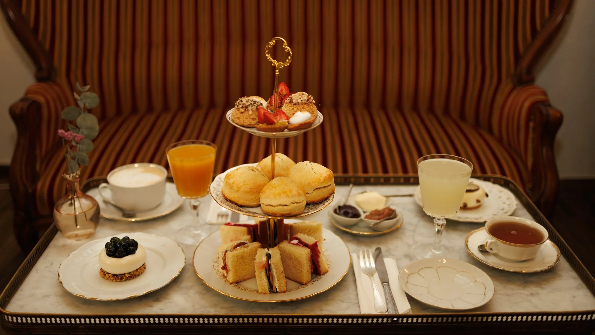 Tea time à l'anglaise présenter sur un serviteur muet en porcelaine devant une banquette du XVème siècle au salon de thé Chez Apolline dans le centre historique de Montpellier