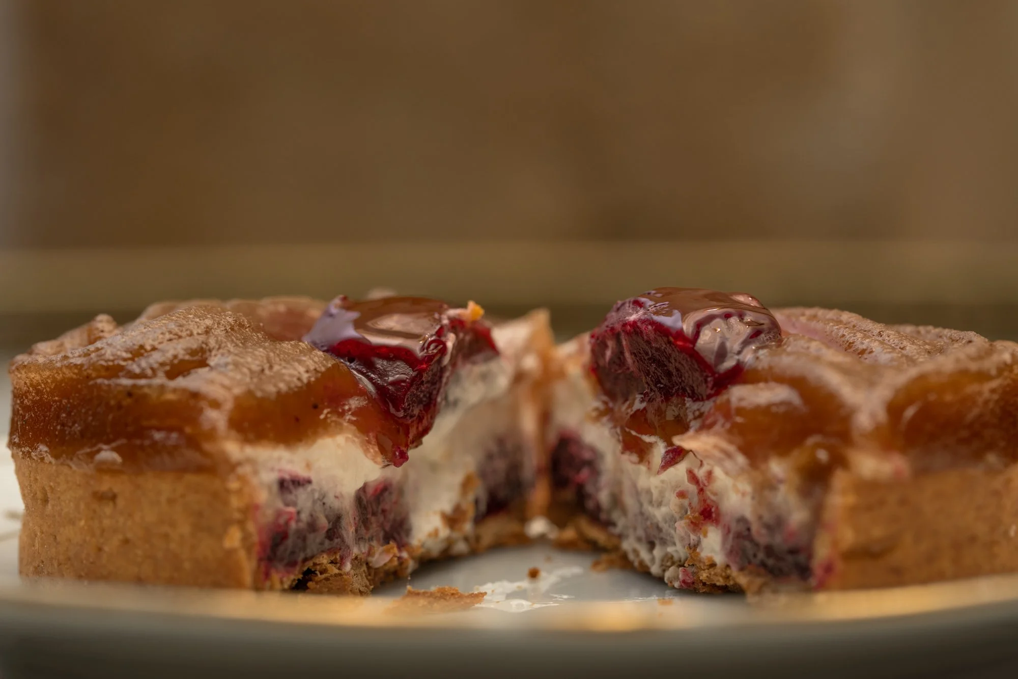 Plan macro sur une tarte crème de marron et cassis coupée en deux