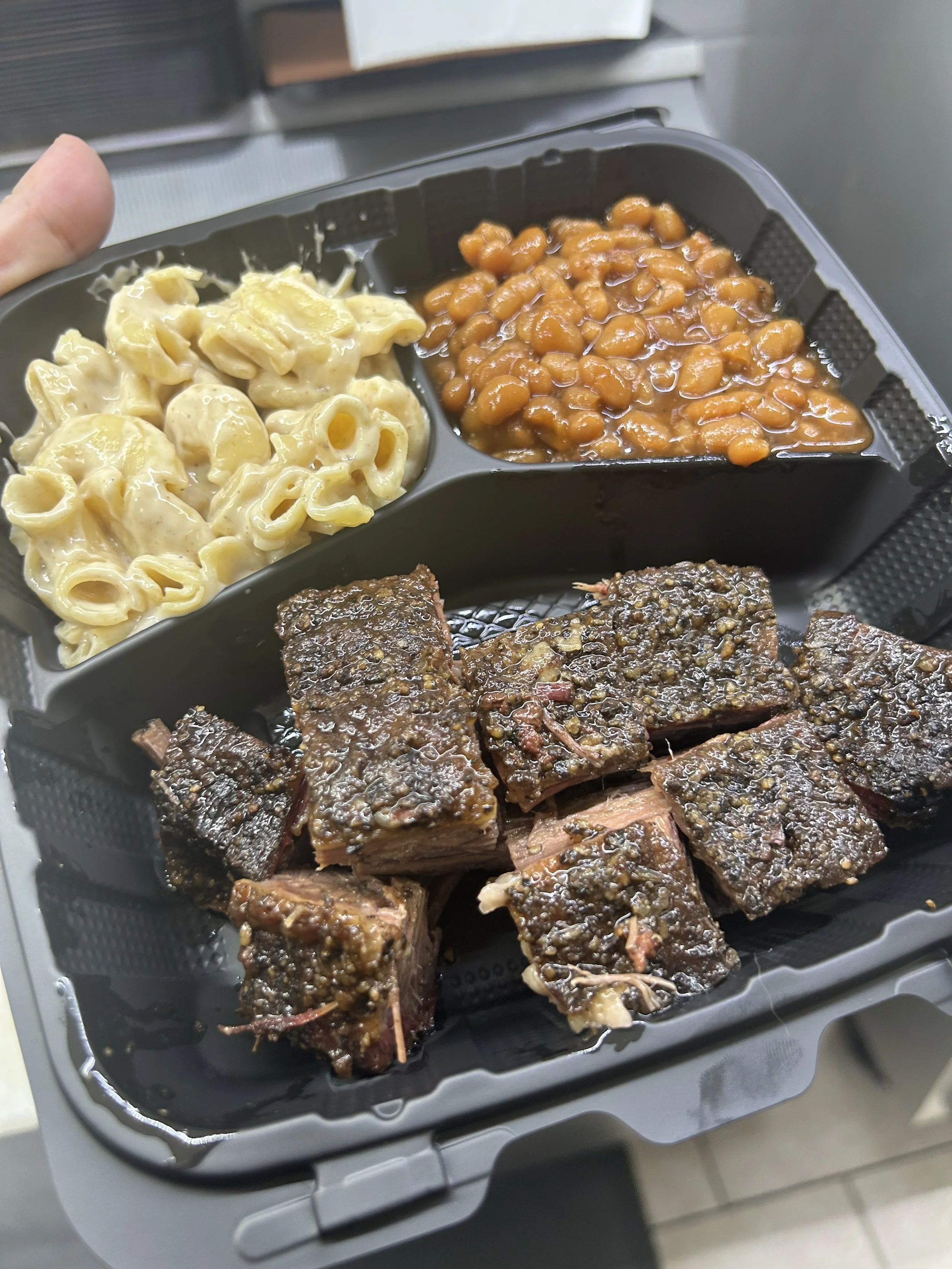 Tray with baked barbecue ribs, baked beans, and macaroni and cheese.