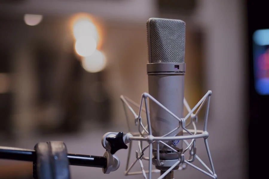 Microphone de studio placé dans un support avec une suspension anti-vibrations, dans une ambiance de studio d'enregistrement.