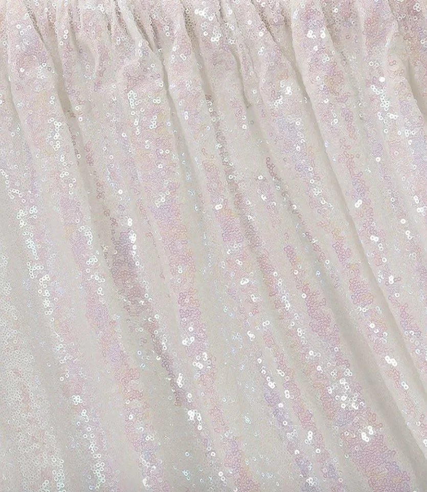 Close-up of a fabric with pale pink sequins, creating a shimmering and textured surface.