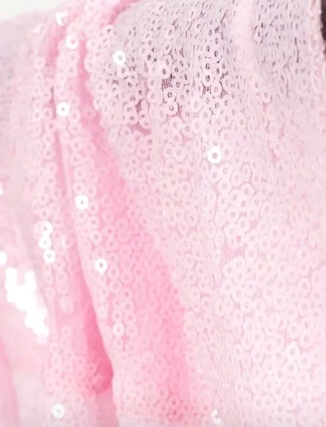 Close-up of pink fabric with shiny sequins.