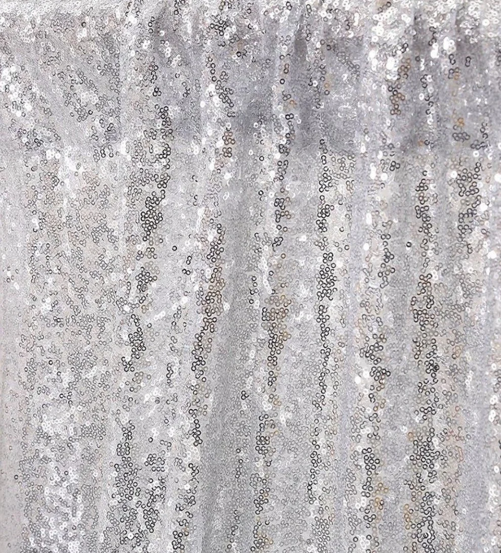 Close-up of a shiny, silver sequined fabric with vertical stripes.