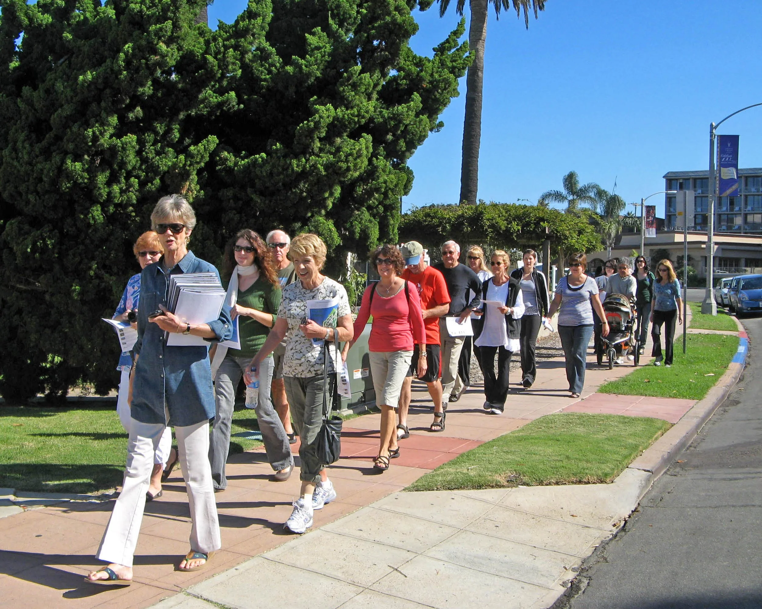 group of adults walking on the sidewalk