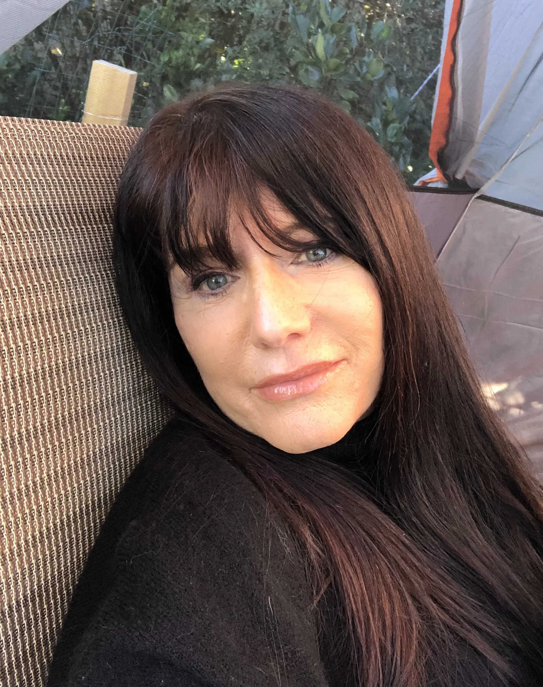 reclining woman with long brown hair and bangs