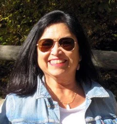 smiling woman with black hair and aviator sunglasses