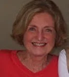 slightly blurry image of woman in red shirt and short hair smiling