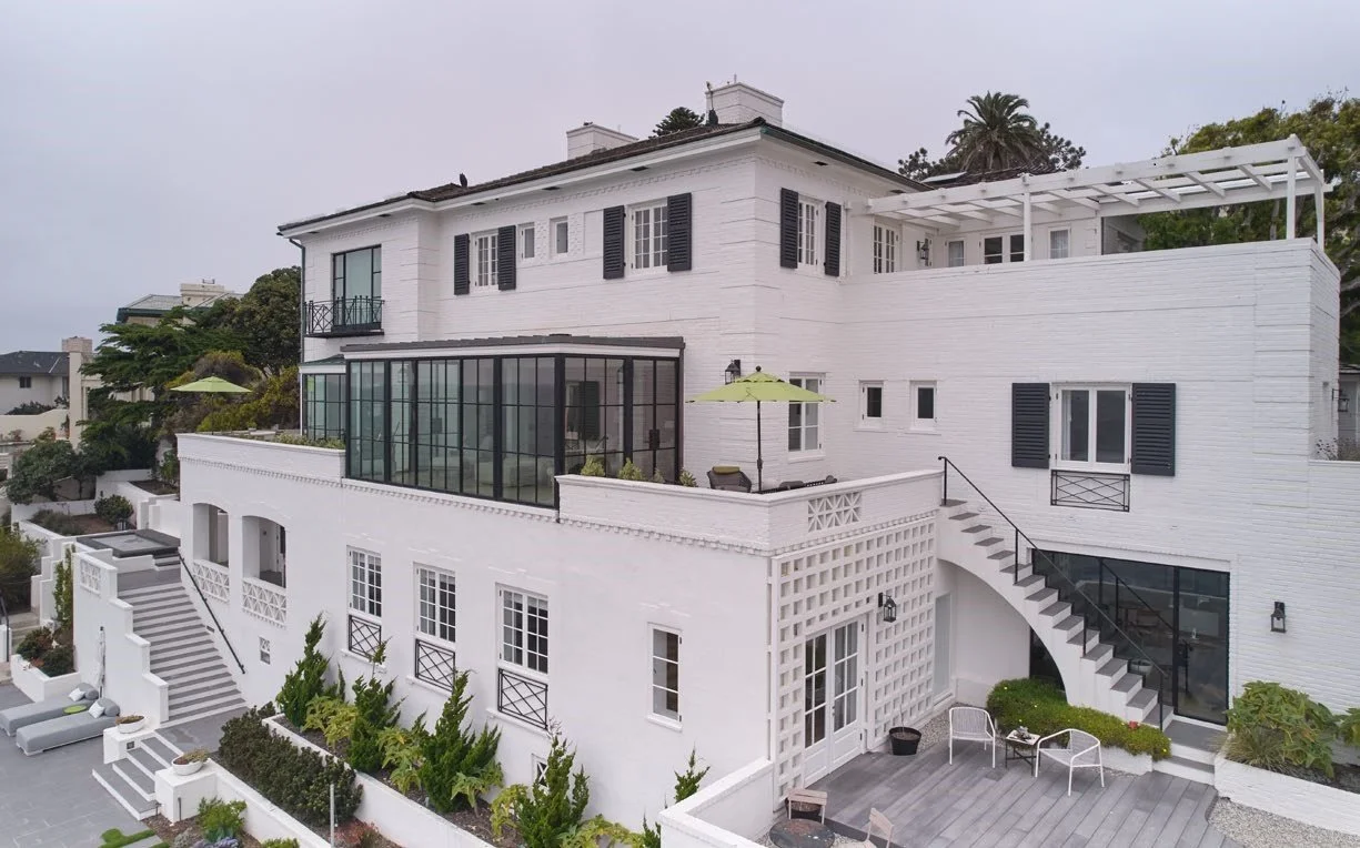 white colonial revival home with a picket fence