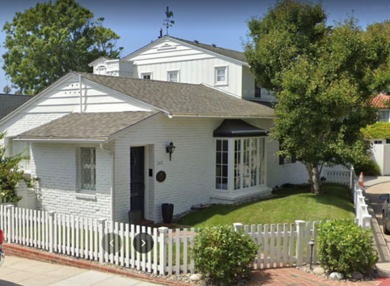 white colonial revival home with a picket fence